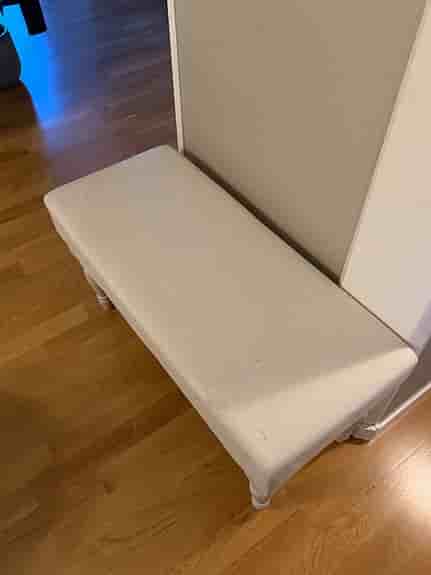 Fin sängpall med vitpigmenterade svarvade ben