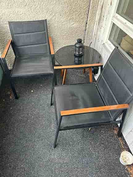 Cafeset två stolar, två-sits sofa med gråa dynor och runt bord svart