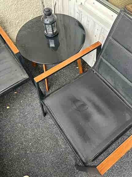 Cafeset två stolar, två-sits sofa med gråa dynor och runt bord svart