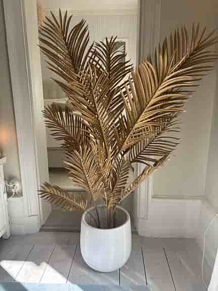 Dekorativ guldfärgad konstväxt palm