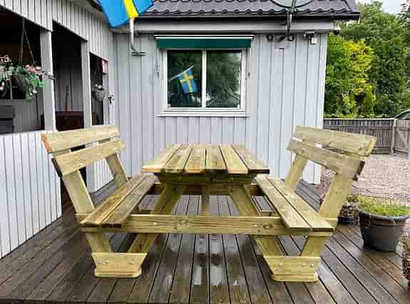 Trädgårdsbord med integrerade stolar och ryggstöd