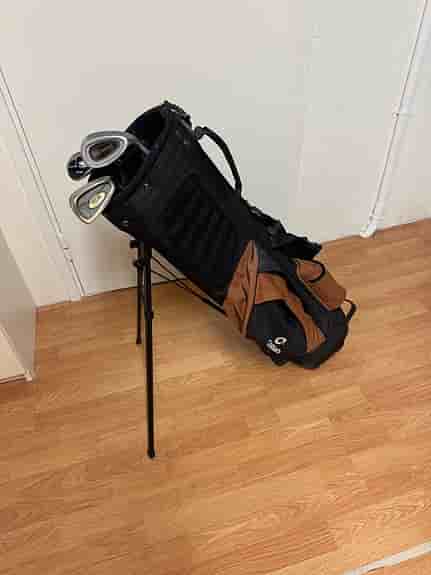 Golfbag med ställ och några klubbor svart/brun