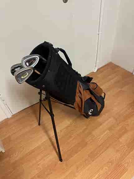 Golfbag med ställ och några klubbor svart/brun