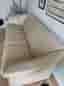 Beige 3-sits skinnsoffa med detaljer i ljus bok
