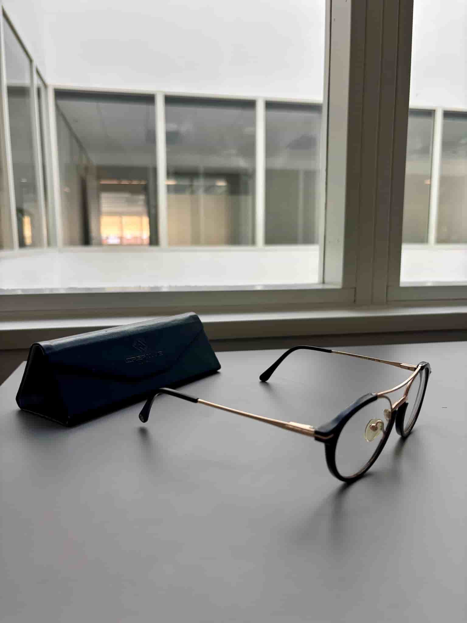 Svarta och guldfärgade glasögon med fodral