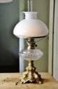 Antik fotogenlampa på metallfot 