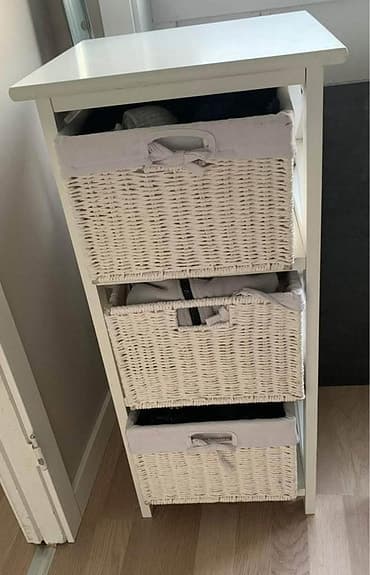 Vit byrå med korgar