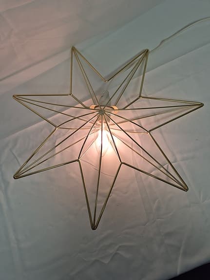 Julstjärna i metall med ljus