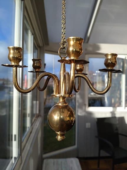 Kapellik ljuskrona i mässing hängande i en kedja.