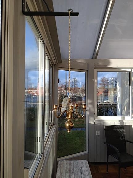 Kapellik ljuskrona i mässing hängande i en kedja.