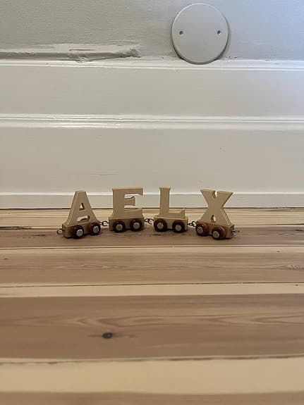 Bokstavståg av trä med bokstäverna: A, E, L, X