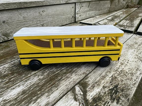Handdekorerad skolbuss i trä – amerikansk modell med rörliga hjul