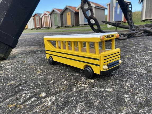 Handdekorerad skolbuss i trä – amerikansk modell med rörliga hjul
