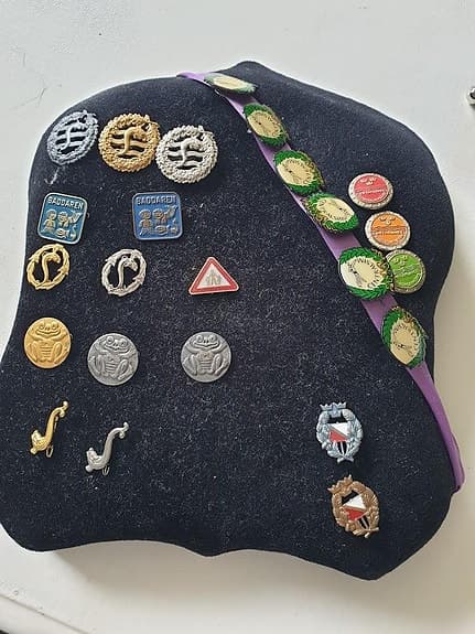 Samling av märken och pins i olika metallmaterial