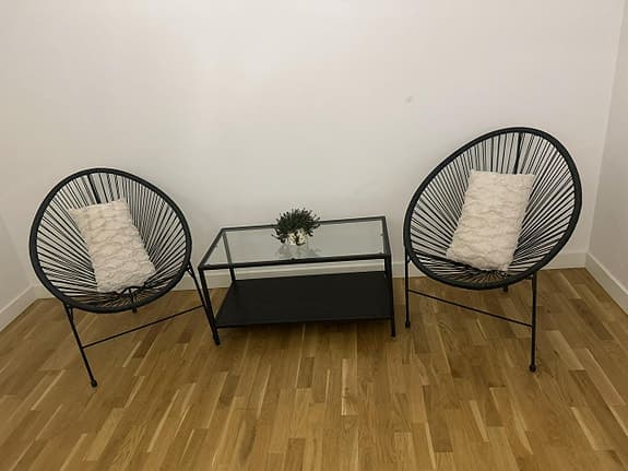Soffgrupp med två svarta stolar och glasbord metall
