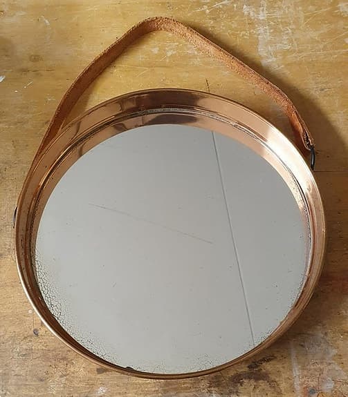 Äldre kopparfärgad spegel med läderrem
