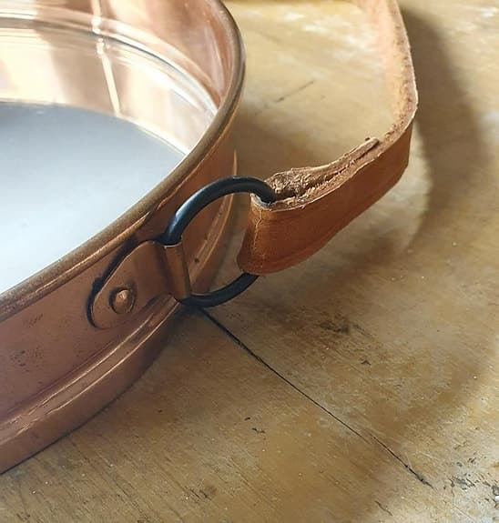 Äldre kopparfärgad spegel med läderrem