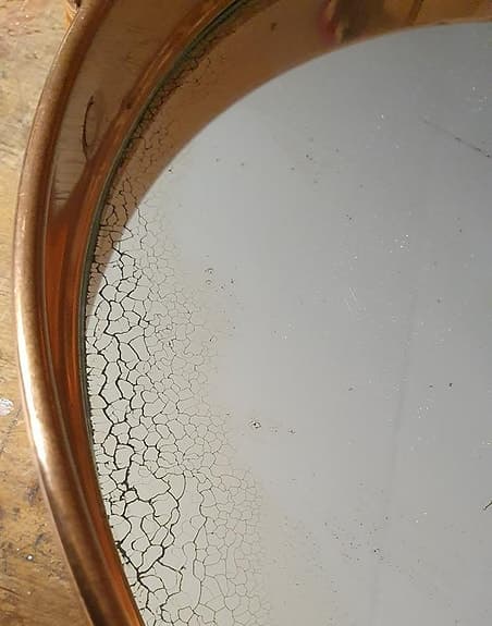 Äldre kopparfärgad spegel med läderrem