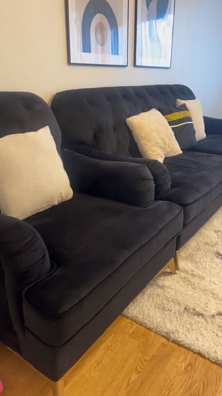 Svart sammetsoffa med fåtölj och soffbord