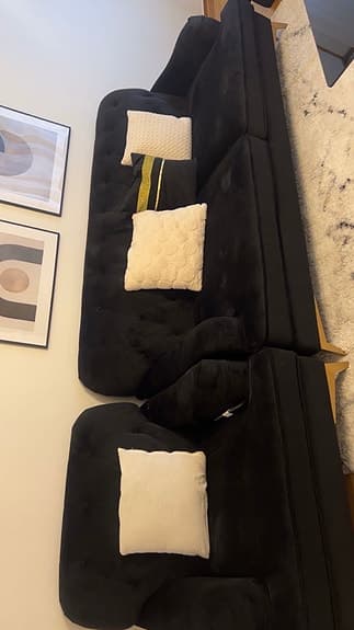 Svart sammetsoffa med fåtölj och soffbord