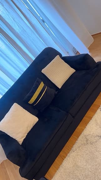 Svart sammetsoffa med fåtölj och soffbord