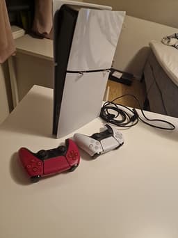 Playstation 5  med två handkontroller (en röd)