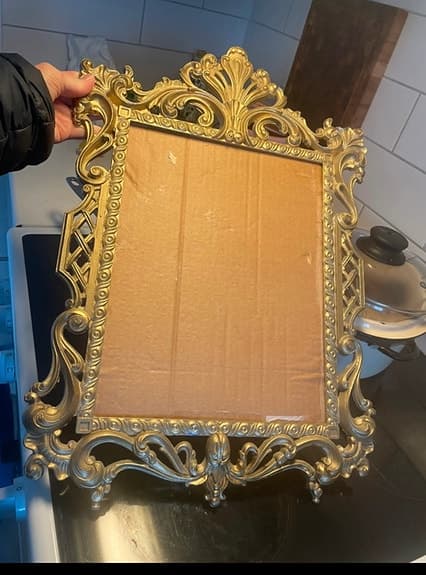 Guldfärgad dekorativ ram till spegel i barockstil