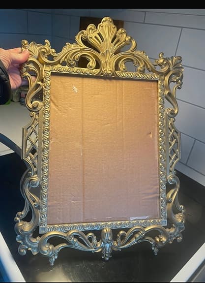 Guldfärgad dekorativ ram till spegel i barockstil