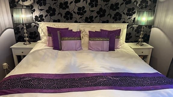 Set med prydnadskuddar och löpare i lila och rosa med dekorativa detaljer
