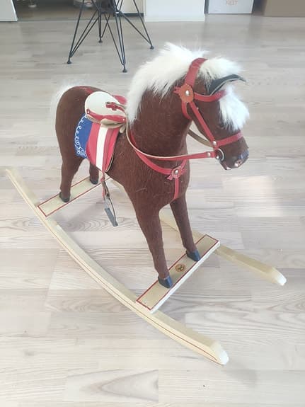 Gunghäst (antik?) i brunt med röd sadel och vita detaljer