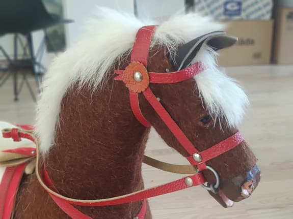 Gunghäst (antik?) i brunt med röd sadel och vita detaljer