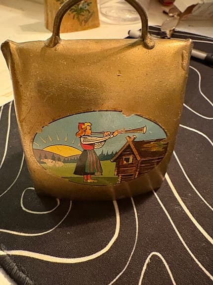 Oidentifierad Klocka i metall med handtag och dekorativ bild