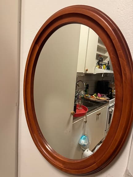 Oval väggspegel i trä