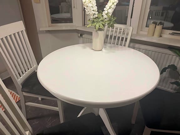 Ett robust, vitt, runt köksbord i