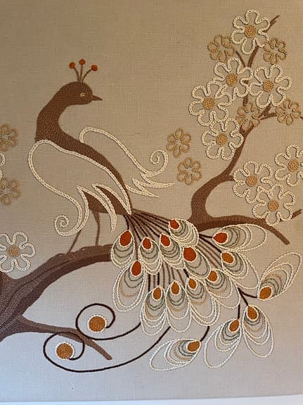 Broderad tavla med påfågelmotiv