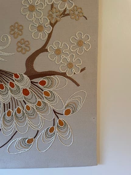 Broderad tavla med påfågelmotiv