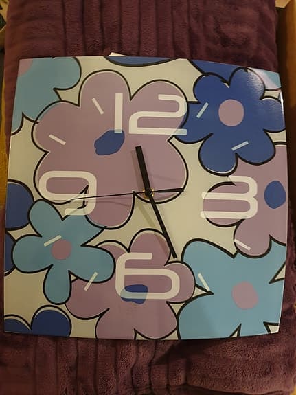 Väggklocka i glas med blommotiv