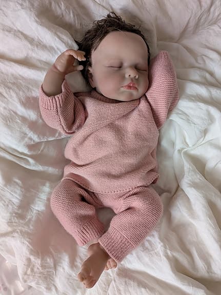 Reborn-docka med rosa stickade kläder, blöja och nappflaska