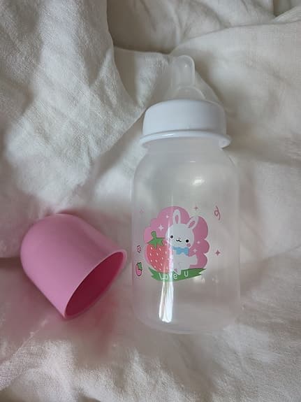 Reborn-docka med rosa stickade kläder, blöja och nappflaska