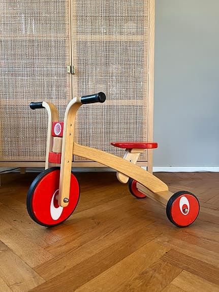 Trehjuling springcykel i trä för lek inomhus