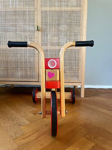 Trehjuling springcykel i trä för lek inomhus