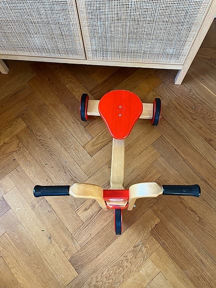 Trehjuling springcykel i trä för lek inomhus