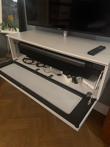 Sony TV med Spectral vägghängd förvaring samt Sonos Soundbar 50 tum