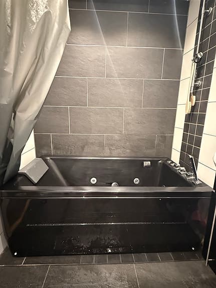 Svart bubbelbadkar med nackstöd