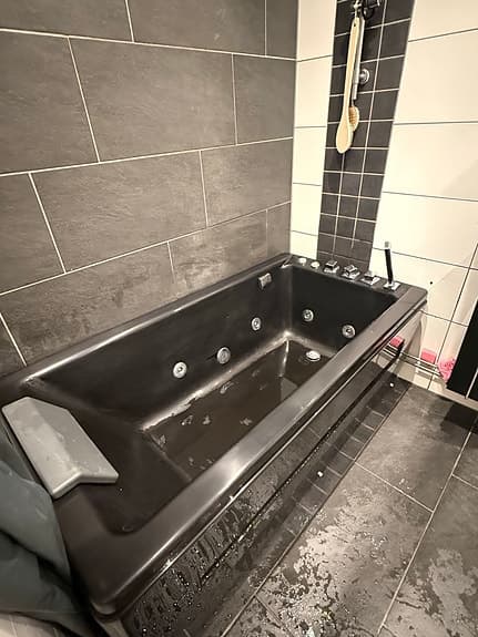 Svart bubbelbadkar med nackstöd