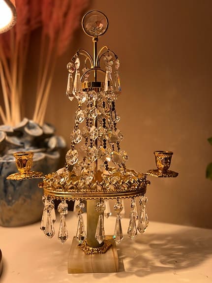 Ljusstake med en tung marmorfot och prismor i strass.