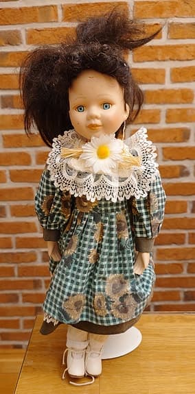 Vintage docka med blommig klänning och spetskrage