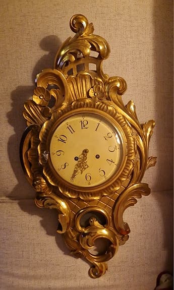 Antik väggklocka i guld 70x50x10 cm.