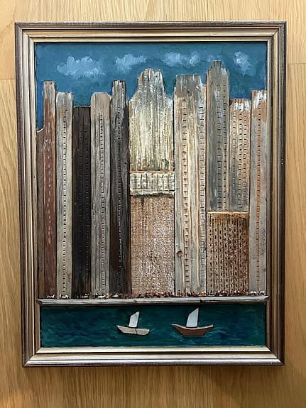 Tavla stadssiluett med båtar trärelief