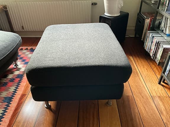 Pall i grått ulltyg med metallben